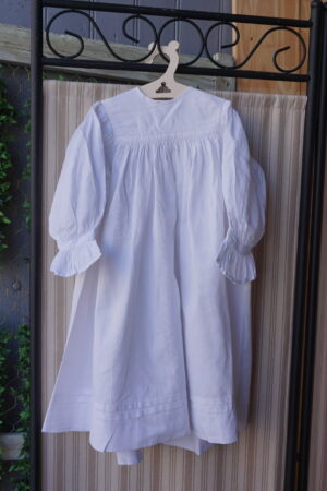 Robe enfant blanche à manches longues – plis & bordures travaillées (1 an) fin XXᵉ / début XXIᵉ siècle