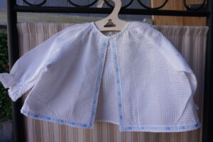 Layette blanche gaufrée – soufflet central au ruban bleu (0/3 mois)  fin XXᵉ / début XXIᵉ siècle